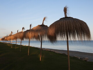 Lustige Bastschirme an einem Mittelmeerstrand im Winter