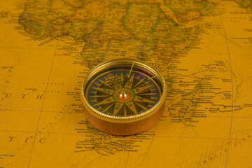 Plakat Compass on old map of the world. Journey and discovery concept