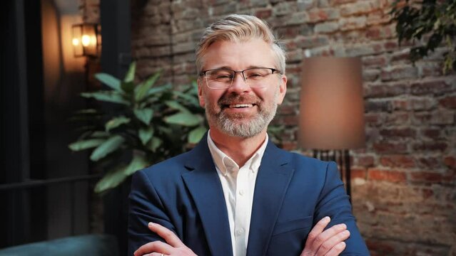 Portrait of smiling handsome businessman in formal wear and glasses standing in office. Head shot close up happy banker advisor executive manager leader owner entrepreneur investor looking at camera.