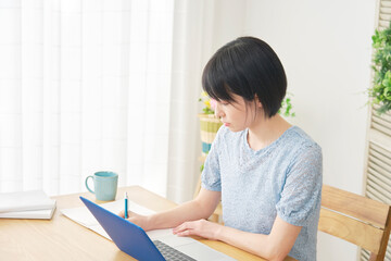 eラーニング　自宅でパソコンを使って勉強する女性