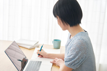 eラーニング　自宅でパソコンを使って勉強する女性