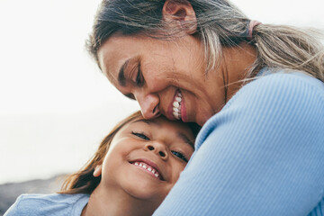 Happy latin mother and daughter having fun together outdoor - Mom day concept - Main focus on kid mouth