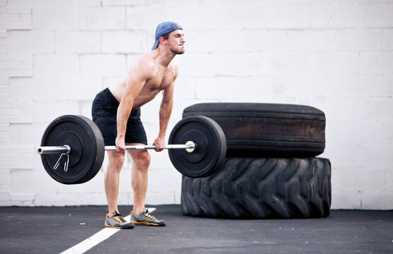 A young man clings weights while doing a fitness boot camp exercise.