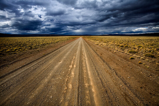 Storm approaches over a desolate gravel road, Patagonia, Argentina.