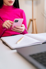 Focused woman using smartphone and laptop