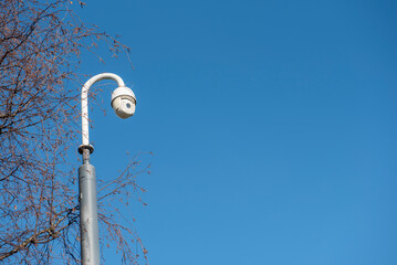CCTV security camera outdoors, taken with a blue sky background 
