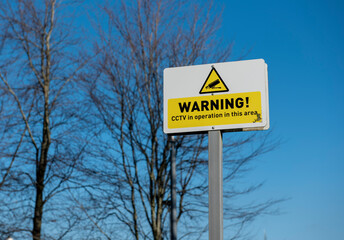 Yellow Warning Sign CCTV in operation, taken with a blue sky background 