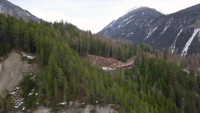 Treno rosso del Bernina passa attraverso un ponte romano 