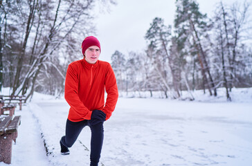 Healthy lifestyle. Young strong man is exercising at snowy park.