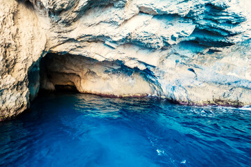 Close-up view of the inside of a sea grotto filled with tropical blue and turquoise water, near...
