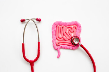 Digestive colon system health concept. Intestines shape made of plasticine with stethoscope