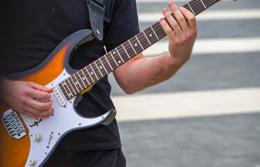 Fototapeta na wymiar a musician plays an electric guitar on a city street.