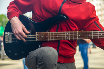 a musician plays an electric guitar on a city street.