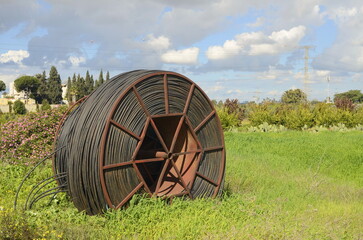Cable drums with fiber optic cable.Technologies poly underground conduit in a green field, on a...