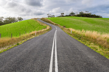 Winding road through Adelaide Hills farms during winter season, South Australia