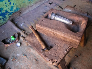 Metal bidriware handicrafts on a wooden sculpting device at a workshop in the town of Bidar.