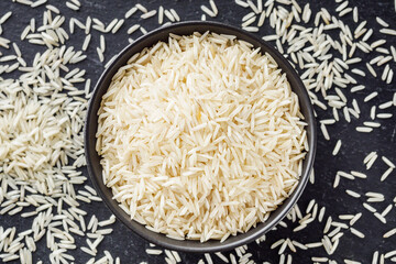 raw basmati rice on a black wooden background