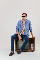 Back in time 90s 80s lifestyle concept. Studio footage of stylish cheerful young man in vintage...