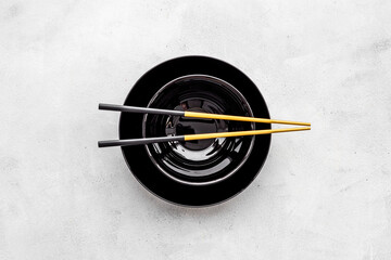 Black bowl with golden chopsticks for Asian tabble place setting