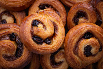 Horizontal closeup image of cinnamon rolls with raisins
