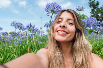 selfie portrait of beautiful young colombian woman in the park, happy smiling and looking at the...