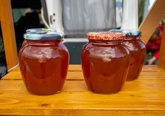 Honey in glass jars. Sale of honey in transparent glass jars at the agricultural market. Sale of beekeeping products.