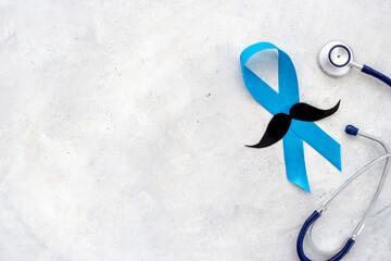 Awareness blue ribbon with a paper mustache. Symbol of prostate cancer