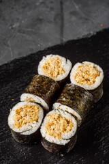 sushi roll maki with baked tuna on a dark background