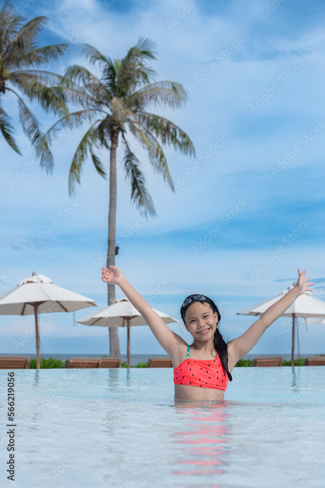 Wall mural Happy girl enjoying summer vacations in a pool. Summer holidays, children's swimming, Pool woman on holidays in tropical resort swimming. summer vacation concept.