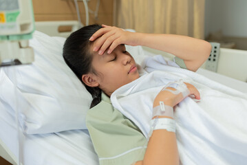 Fototapeta na wymiar Asian woman patient with medical drip have headache with migraine headaches hospital ward, teenager sick in hospital with saline intravenous, Selective focus, healthcare and health insurance concept.