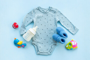 Baby cotton bodysuit with bottle of milk and toys