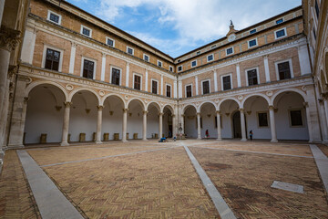 Beautiful places of Italy. View of renaissance courtyard of the Ducal Palace of Urbino , city and...