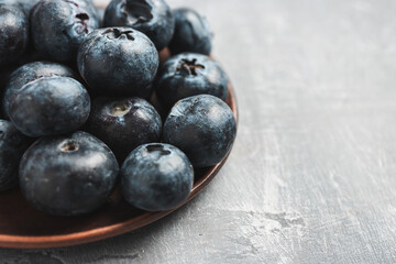 Fresh blueberries in a plate on a table, close up view