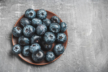 Fresh blueberries in a plate on a table, top view