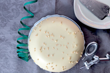 White chocolate birthday cake with candles seen from above
