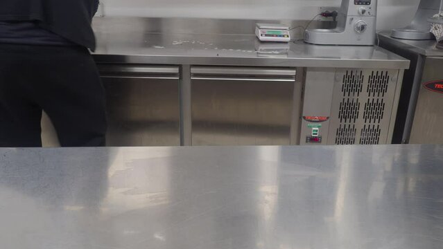 person sanitizing surfaces and areas in professional kitchen - food security concept
