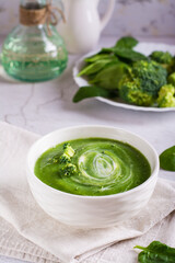 Fresh broccoli puree soup in a bowl on the table. Vegetarian food. Vertical view