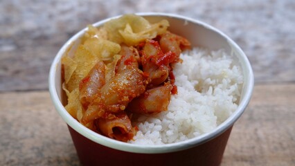 Rice bowl with spicy squid and potato chips. Nasi cumi asin 