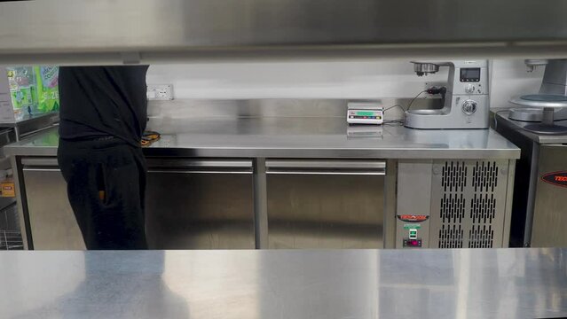 person sanitizing surfaces and areas in professional kitchen - food security concept