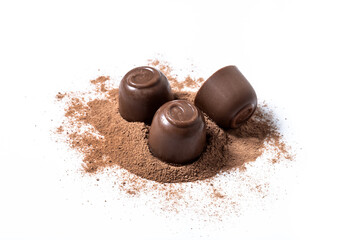 Chocolate bonbons and cocoa powder isolated on white background
