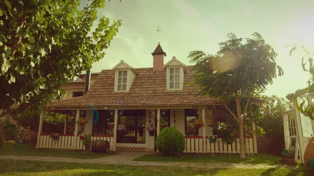Beautiful cosy village house with trees , lawn , weathervane and mailbox . Dolly movement shot of vintage countryside home at sunny daytime . Retro designed mail box outside . Close up 