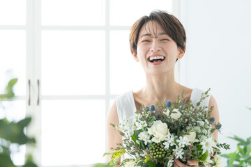 花束を持った笑顔のミドル女性