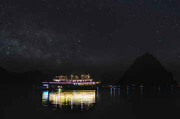 ships and boats anchored at night in the Ha Long bay in South China Sea