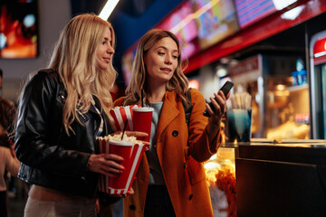 Friends paying online in movie theater.