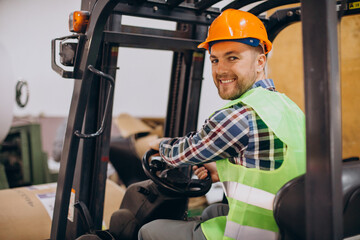 Man working at warehouse and driving forklift - Powered by Adobe