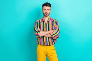 Portrait of serious ambitious confident guy with brunet haircut wear colorful shirt hold arms...