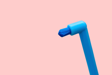 Single-tuft brushes, new blue toothbrush with single beam isolated on pink background....