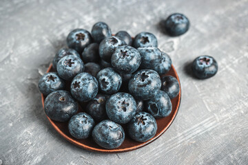 Fresh blueberries in a plate on a table, close up view