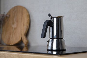 a moko geyser coffee machine makes coffee on an electric induction stove in the kitchen