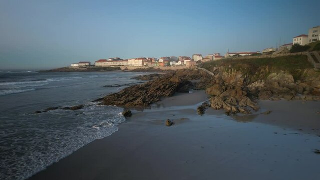 Rocky shoreline Of Praia de Arnela In Caion, A Coru&ntilde;a, Spain. - aerial pullback